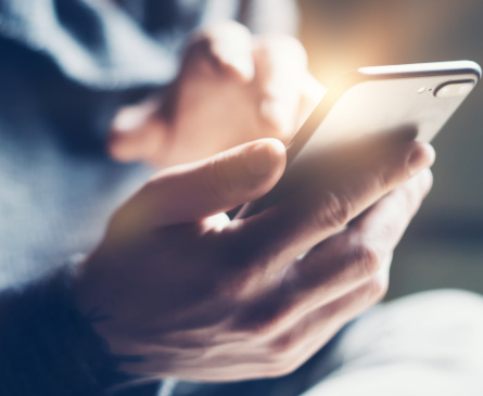 Foto: ein Smartphone in der Hand einer Person.